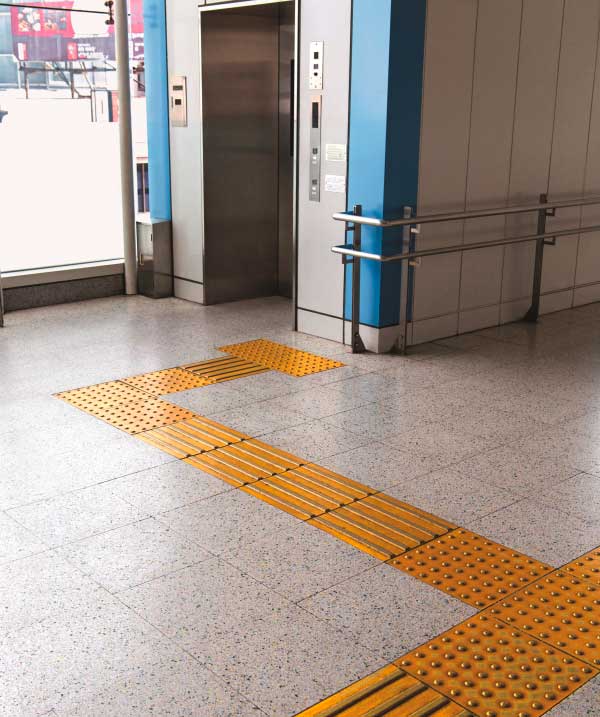 Taktile Bodenleitstreifen weisen den Weg zu einem Fahrstuhl.